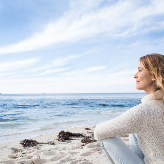 blond woman sitting on the beach in winter